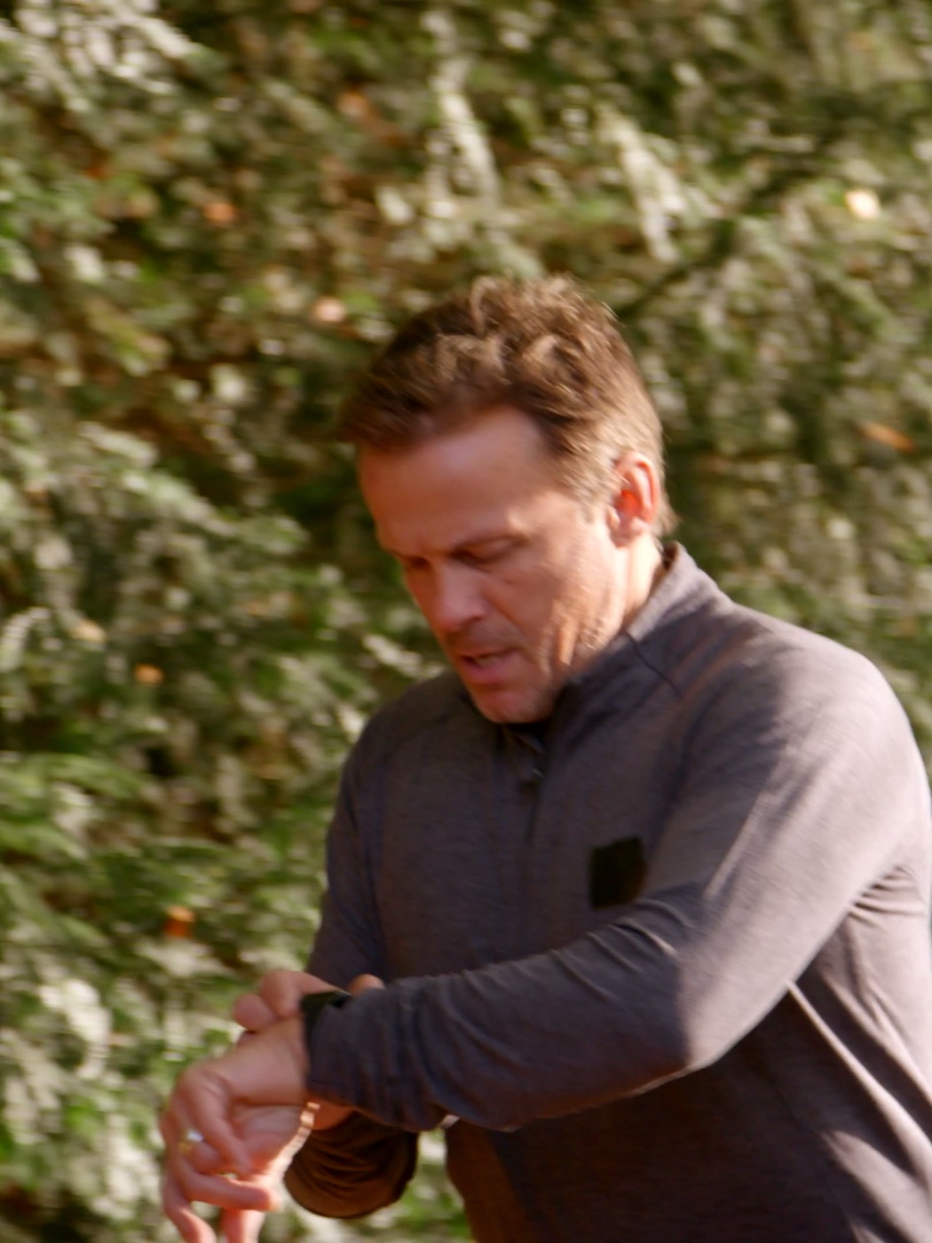 Man checking his watch part-way through a run